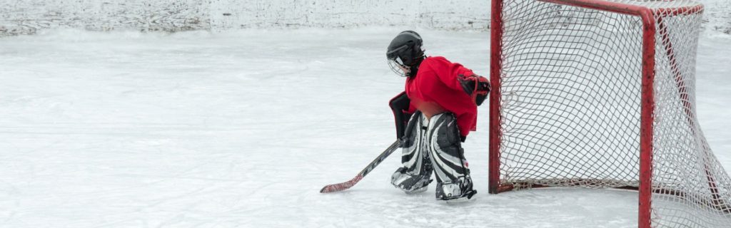 Photo d'un jeune gardien de but de hockey seul devant son filet